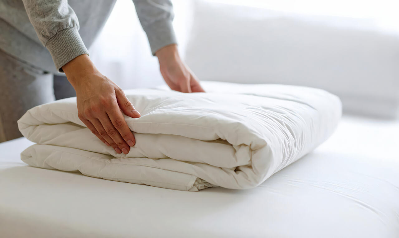 クリーニングでふかふかになった布団とお客様の満足した笑顔